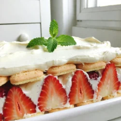 - Fresh strawberries: Use 2 cups, hulled and sliced. This gives the cake its sweet and fruity flavor. Choose ripe berries for the best taste. - Heavy whipping cream: You need 1 cup. For the best results, chill your mixing bowl and beaters before whipping. This helps the cream whip up nicely. - Mascarpone cheese: Use 1 cup. Look for a smooth and creamy texture. This cheese adds richness and depth to the cake. - Vanilla extract: You need 1 teaspoon. Always use pure vanilla extract. It enhances the flavor and makes your cake taste more special. - Ladyfinger cookies: You&rsquo;ll need 16-18 cookies. Store-bought varieties work well. These cookies soak in the flavors and soften, creating nice layers. - Garnish: Fresh mint leaves are great for presentation. They add a pop of color and a hint of freshness to your cake. {{ingredient_image_1}} To make the strawberries pop, you need to macerate them. Start by slicing 2 cups of fresh strawberries. Place them in a bowl and sprinkle with 1 tablespoon of granulated sugar. Mix gently to coat the strawberries. Let them sit for about 15 minutes. This time allows the sugar to draw out the juices. The result is a sweet syrup that adds flavor to your cake. For the best taste, use strawberries that are ripe. This step boosts the overall flavor of your dessert. Next, let&rsquo;s whip the cream. Pour 1 cup of heavy whipping cream into a bowl. Use a hand mixer or a whisk. Whip until soft peaks form. This means the cream holds its shape but is still soft and fluffy. Now, add 1 cup of mascarpone cheese and 1 teaspoon of vanilla extract to the whipped cream. Gently fold the mixture. Make sure it is smooth and fully combined. This step creates a rich and creamy filling. Now, it's time to layer the cake. Start by laying 16-18 ladyfinger cookies in the bottom of a 9x9 inch baking dish. These cookies will soak up the strawberry juices, adding flavor and texture. Spoon half of the mascarpone mixture over the ladyfingers. Spread it evenly for a nice base. Next, layer half of the macerated strawberries over the mascarpone. Repeat the layers with the remaining ladyfingers, mascarpone mixture, and strawberries. This creates a beautiful and tasty dessert. After layering, cover the dish with plastic wrap. Refrigerate it for at least 4 hours or overnight. This resting time helps the flavors meld and the cookies soften. Chilling your cake is key. It helps the flavors blend and the layers set. I suggest refrigerating it for at least four hours. Overnight is even better. This gives the ladyfingers time to soak up the juices. Serve it cold for the best taste and texture. Sometimes, layers may not set well. If this happens, you can try adding more whipped cream. This extra cream helps firm the layers. If your cake is too sweet, mix in a pinch of salt. This balances the flavors and tones down the sweetness. You can get creative with toppings. Try using whipped cream or coconut flakes for fun textures. Fresh berries on top add color and flavor. For a touch of elegance, consider adding edible flowers. They make your cake look stunning and special. Pro Tips Use Ripe Strawberries: Choose strawberries that are fully ripe for the best flavor. They should be bright red and fragrant. Chill Your Ingredients: For a fluffier whipped cream, make sure your heavy cream and mixing bowl are well chilled before whipping. Let It Rest: Allow the cake to chill overnight for the best texture and flavor as it gives the ladyfingers time to absorb the moisture. Experiment with Flavors: Feel free to add a splash of liqueur, like amaretto or orange liqueur, to the mascarpone mixture for an adult twist. {{image_2}} You can switch up the fruit to make this cake your own. Try using berries like blueberries or raspberries. Peaches also work well and add a nice twist. Seasonal fruits like mangoes can bring a fresh taste in summer. If you prefer a dairy-free option, replace mascarpone with coconut cream or a nut-based cheese. These swaps keep the cake creamy while catering to dietary needs. Add some crunch by incorporating nuts like almonds or walnuts. Layering chocolate pieces can also add a rich flavor. If you want a different base, consider using sponge cake instead of ladyfingers. Sponge cake offers a softer bite and soaks up the flavors beautifully. Think about making themed versions for special occasions. For holidays, you can add festive colors with seasonal fruits, like cranberries for Christmas. In fall, use pumpkin spice for a twist on the classic recipe. You can also make mini versions for parties, using small cups for individual servings. Each theme can make your icebox cake feel fresh and exciting! To keep your icebox cake fresh, cover it tightly. Use plastic wrap or a lid. This helps prevent drying and keeps flavors strong. Store it in your fridge for up to three days. If you see any condensation, open the lid slightly to let moisture out. For the best container, I recommend a glass or plastic dish with a tight seal. These materials keep the cake cool and fresh. Avoid metal containers as they can affect the taste of the dessert. You can freeze the strawberry shortcake icebox cake for longer storage. First, cover the cake well with plastic wrap. Then, place it in an airtight container. This prevents freezer burn and keeps it tasty. It&rsquo;s best to freeze the cake before adding any garnish. When you&rsquo;re ready to enjoy it, take it out of the freezer. Let it thaw in the fridge for several hours. This keeps the texture nice and smooth. If you need it quicker, set it on the counter for about an hour. Just remember not to rush it, as slow thawing gives the best results. The Strawberry Shortcake Icebox Cake stays fresh for about 3 to 4 days in the fridge. Store it in an airtight container to keep it safe from other smells and moisture. The strawberries may soften over time, but the flavors deepen, making it even tastier! Yes! You can make this cake a day in advance. This gives the flavors more time to blend. Just remember to cover it well with plastic wrap. It will taste great when you serve it the next day! The main difference is how they are made. Icebox Cake uses layers of ladyfinger cookies, cream, and fruit. Traditional Strawberry Shortcake uses a biscuit or sponge cake. The texture of Icebox Cake is creamy and soft, while traditional shortcake is more crumbly and dense. You can use frozen strawberries, but they will change the texture slightly. Thaw them first and drain excess juice. They may not taste as bright as fresh ones, but they will still work well in the cake. You&rsquo;ve learned how to make a delicious Strawberry Shortcake Icebox Cake. We covered key ingredients, step-by-step instructions, and creative variations. Remember to choose the right strawberries and use pure vanilla extract for the best flavor. Pay attention to chilling time and layering for perfect texture. This dessert offers room for creativity, so feel free to make it your own. Whether for a special occasion or just a treat, this cake is sure to impress. Enjoy your baking journey and savor each bite!